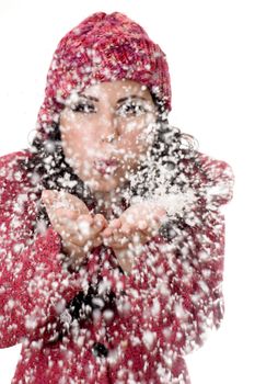 Woman blowing soft white flakes.  Focus on woman, flakes are  in motion.