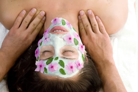 A woman enjoys a therapeutic neck massage during a facial treatment 
- landscape