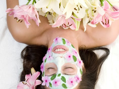 Spa Beauty - Beutiful woman relaxing in a botanical mask with flowers decoration
- landscape.