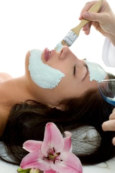 A beautician applying a facial treatment mask