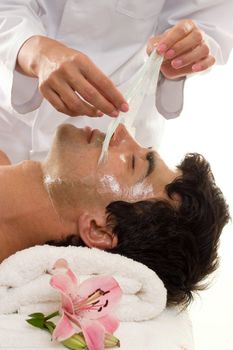 Facial Peel - A beautician performs a facial peel on a male client.
