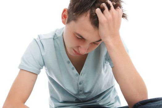 A boy sitting with head in hand - sad, depressed, stress, headache, etc