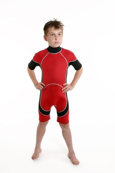 A young boy standing wearing a red and black wetsuit