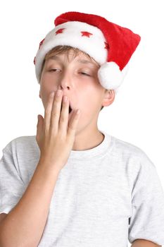 A child showing tiredness or boredom. He is wearing a grey shirt and santa hat.