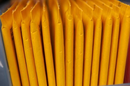 Some yellow, stuffed envelopes with cracks lined up in a row