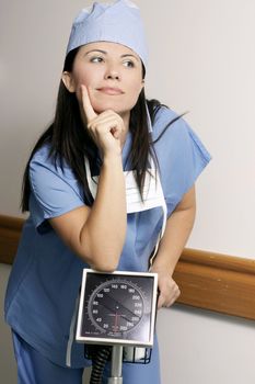Female healthcare worker with standard medical equipment in a hospital corridor.