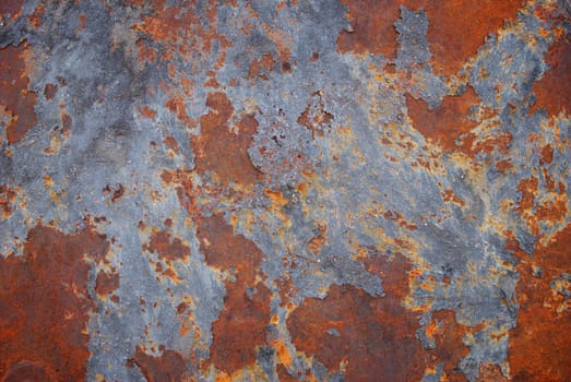 A rusted metal panel with bright orange and dark gray sploches