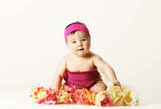 Baby girl in smocked pink top with floral leis.  
Added contrast.
Enhanced eye colour
Jasmine is only 5mths old and needed to be propped up by her mother (behind set)