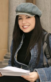 Student holding papers and smiling.