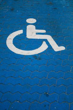 Parkingspace for Handicapped with wheelchair symbol on blue paint