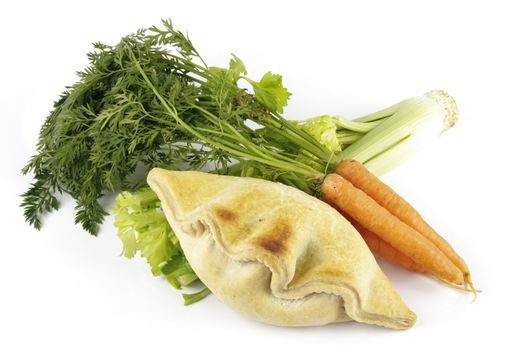 Contradiction between healthy food and junk food using a bunch of carrots and celery with a pasty on a reflective white background 