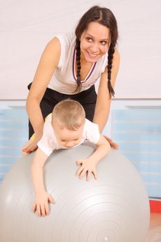 Mum with the son play a sports hall
