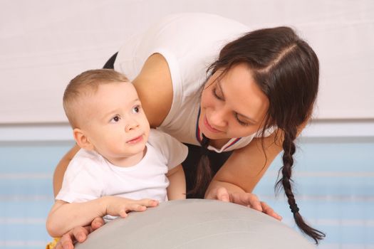 Mum with the son play a sports hall
