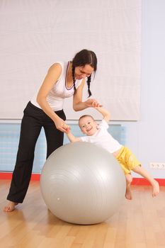 Mum with the son play a sports hall
