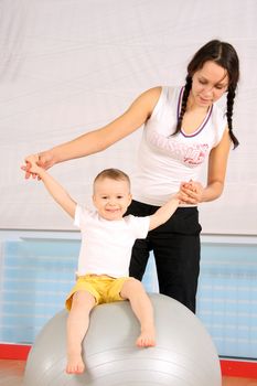 Mum with the son play a sports hall
