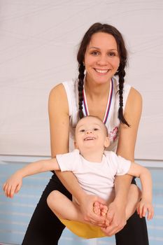 Mum with the son play a sports hall
