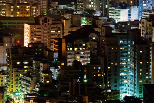 Landscape of city apartments illuminated in the night.