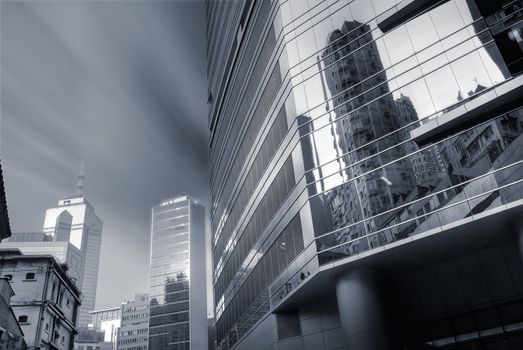 Tall buildings and mansions with clouds motion blurred.
