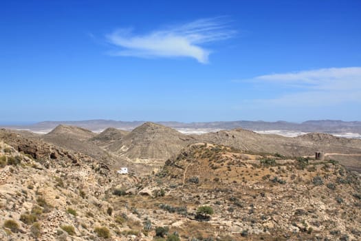 Arid landscape in Nijar, with white greenhouses in the background. Province of Almeria, Andalusia, Spain.