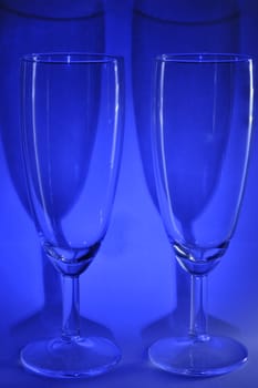 Two of the same glasses of wine on the blue background.