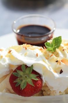 A vanilla ice cream with a strawberry, a mint leaf and nougat decoration, covered with fresh whipped cream. In Europe this ice cream is known as a Dame Blanche