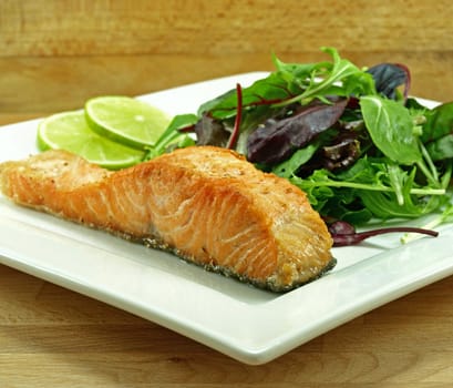plate of freshly fried salmon fillet with baby greens