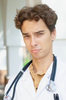 Close-up portrait of an upset young doctor