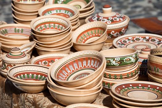 Rustic handmade ceramic and clay brown pots decorated by traditional ornament and pattern at the handicraft market