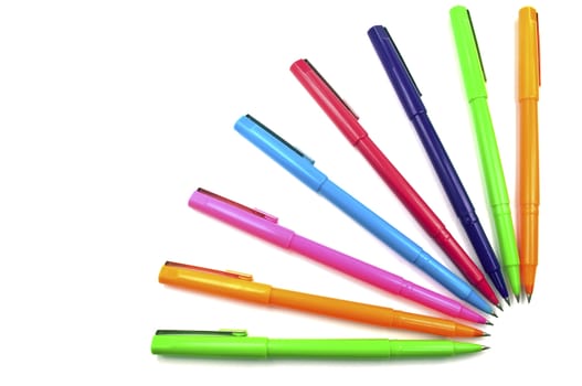 Set of multi color pens on white background.