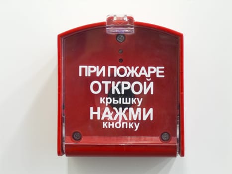 The button of the fire signal system on a white wall.