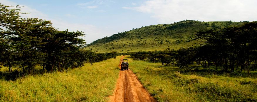 A jeep traveling on a dirt road in africa