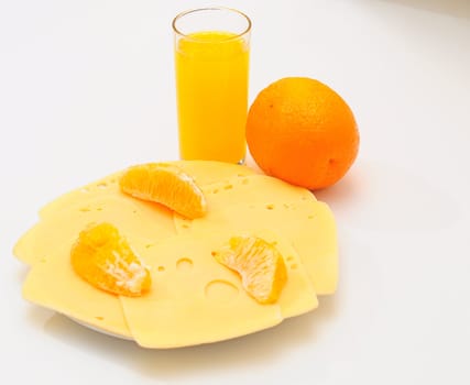 Yellow cheese  on the  plate.Orange juice in a glass.