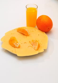 Yellow cheese  on the  plate.Orange juice in a glass.