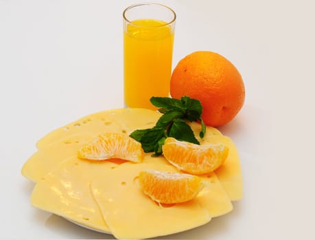 Yellow cheese  on the  plate.Orange juice in a glass.