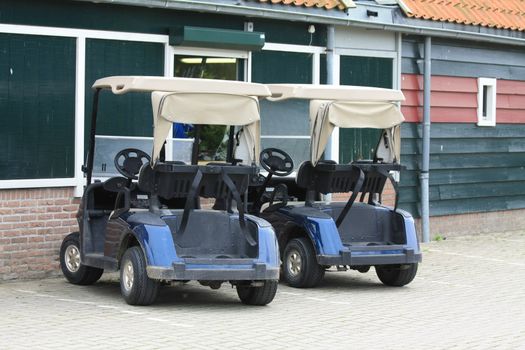 Two golf carts on a parking lot