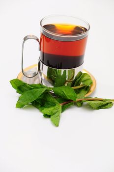 A glass of hot tea on a saucer.