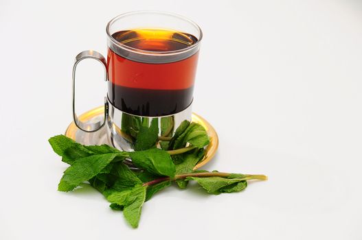 A glass of hot tea on a saucer.