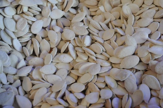 Pile of salted pumpkin seeds, close up image .