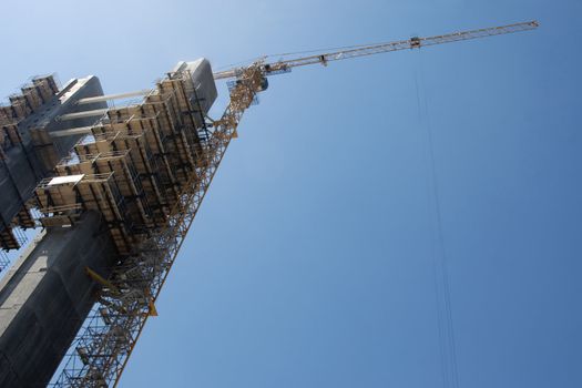 tower crane working on construction on blue sky background