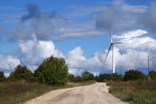 Wind turbine on a background of the blue sky and clouds