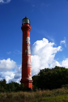 Beacon on a background of the blue sky and clouds