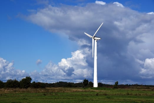 Wind turbine on a background of  blue sky and clouds