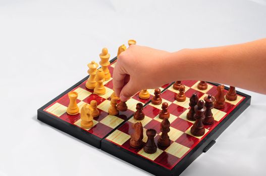 Young child playing chess on traditional  chess set .