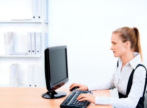 Woman works at the computer. Screen has a clipping path.