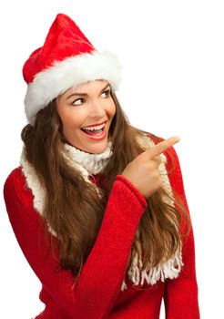 A beautiful young smiling woman wearing a santa hat and pointing to copyspace