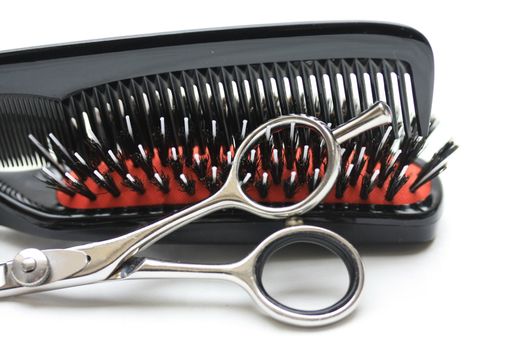 A pair of hairdressers scissors, a comb and a brush, the basic equipment for any hairdresser