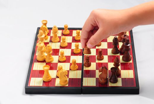 Young child playing chess on traditional  chess set .