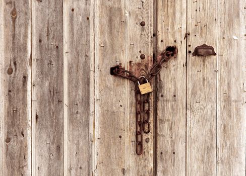 an old wooden door closed with a chain