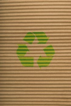brown corrugated cardboard texture, striped horizontally paper and green recycling sign