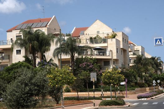 Modern homes in Israel.Modern apartment block and palm trees .